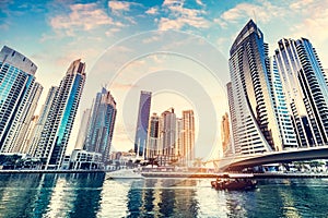 Dubai marina and tourist boat at sunset.