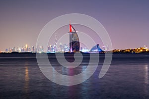 Dubai night landscape showing luxury skyline of modern hotels and skyscrapers. Illuminated Burj al Arab and Burj Khalifa.