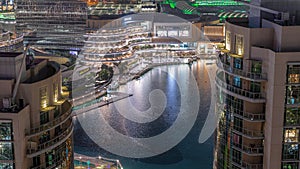 Dubai singing fountains with walking area around aerial night view between skyscrapers timelapse.