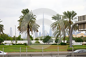Dubai skyline, Burj Khalifa skyscraper and palm trees in a cloudy day
