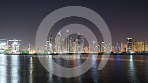 Dubai skyline at night with colorful reflections on the water