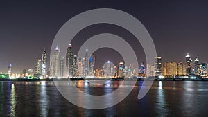 Dubai skyline at night with colorful reflections on the water