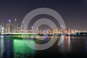 Dubai skyline at night with colorful reflections on the water