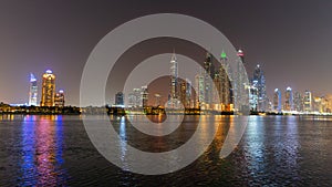 Dubai skyline at night with lights on the water and luxirious skyscrapers of UAE photo