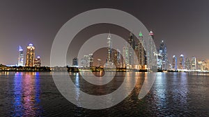 Dubai skyline at night with lights on the water and luxirious skyscrapers of UAE photo