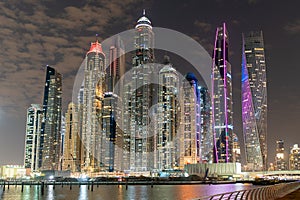 Dubai skyline at night with lights on the water and luxirious skyscrapers of UAE.
