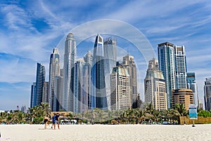 Dubai skyscraper skyline with palm trees and the sand of the beach