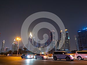 Dubai skyscrapers at night with road traffic late at night.