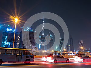 Dubai skyscrapers at night with road traffic late at night.