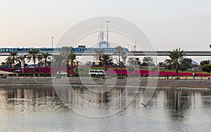 Dubai, UAE - 12.21.2022 - Metro train with Burj Al Arab hotel on the background. City