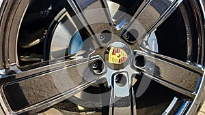 Dubai, UAE- January, 2020. Close-up of famous Porsche logo on black wheel rim with brakes