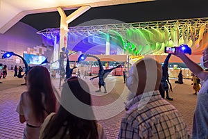 Dubai, UAE - November 28, 2021: People watching dragons performance at night at Expo2020, funny atmosphere. People from