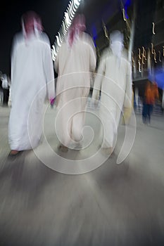 Dubai UAE small group of traditionally dressed Muslim men roaming grounds at Nad Al Sheba