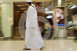 Dubai UAE Two men traditionally dressed in dishdashs and gutras white robes and headdresses.