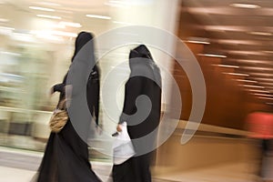 Dubai UAE Two women dressed in traditional abayas and hijabs black robes and scarves. photo