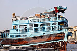 The reverse side of the capital seaport. A small wooden  private no name merchant ships and boats  with old cars against  of urban