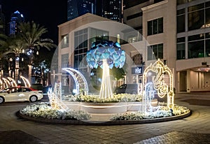 Night view to decorative small square with illuminated Muslim symbols at Dubai Marina in Dubai city, United Arab Emirates