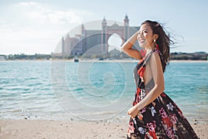Dubai, United Arab Emirates. Pretty asian girl infront of Atlantis the Palm hotel from The Pointe waterfront dining and