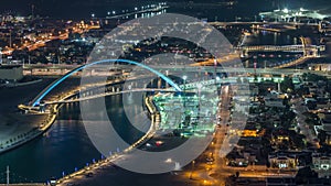 Dubai water canal with footbridge aerial night timelapse from Downtown skyscrapers rooftop