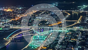 Dubai water canal with footbridge aerial night timelapse from Downtown skyscrapers rooftop