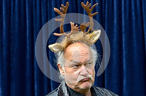 Dubious man wearing gold reindeer antlers