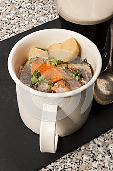 Dublin coddle in a mug on slate