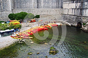 Dubrovnik, Croatia - June 02, 2017: Lot of red and yellow kayacs pulled on shore near the wall of the Dubrovnik old fortress.