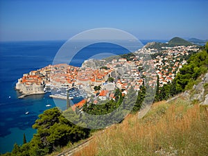 Dubrovnik, Croatia, top view from the cliff. Blue Adriatic Sea, the old town lies at the foot of the mountain. Red tile roofs look