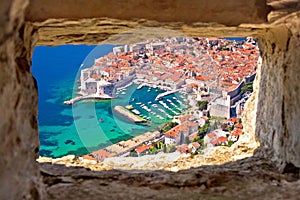 Dubrovnik historic city and harbor aerial view through stone win