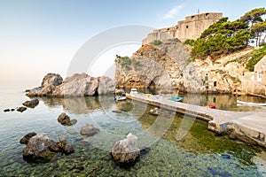 Dubrovnik old city small west harbor with boats. Near is the Lovrijenac fortress. Summer weather, morning soft light. Part of