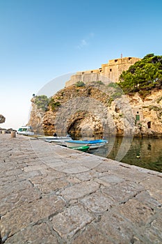 Dubrovnik old city small west harbor with boats. Near is the Lovrijenac fortress. Summer weather, morning soft light. Part of