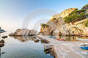 Dubrovnik old city small west harbor with boats. Near is the Lovrijenac fortress. Summer weather, morning soft light. Part of