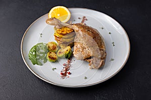 Duck leg confit with Brussels sprouts, baked potatoes, thyme and orange. Traditional French cuisine.