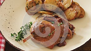 of a duck leg confit with sarladaise potatoes on a plate