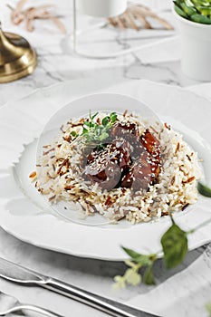 Duck liver fuagra and rice with sauce at the white plate on light marble background. Healthy sea food, hard light, restaurant