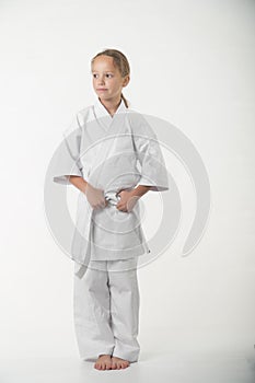 A duduka is standing in a kimano on a white background. Karate is insulated.