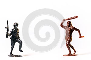 A duel between a vintage toy soldier and a primitive man, isolated on a white background