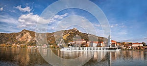 DUERNSTEIN CASTLE AND VILLAGE WITH BOAT ON DANUBE RIVER DURING AUTUMN TIME IN AUSTRIA