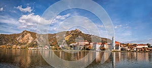 DUERNSTEIN CASTLE AND VILLAGE WITH BOAT ON DANUBE RIVER DURING AUTUMN TIME IN AUSTRIA