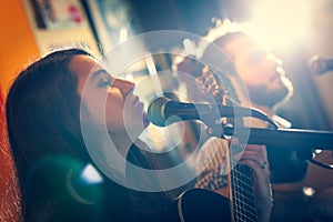 Duet of guitarists singing during a musical performance