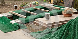an dug grave with green grass mats