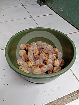 The dukuh fruit in the plastic basin had rotted