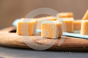 Dulce de leche in cubes on a wooden board. photo