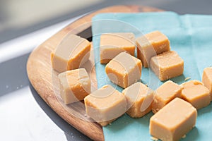 Dulce de leche in cubes on a wooden board. photo