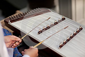 A dulcimer which Thai traditional music instrument. Man playing hammered dulcimer with mallets.
