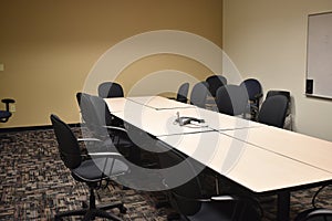 Dull empty conference room in an office building with black chairs and neutral tables and colors