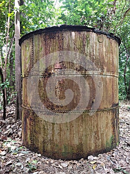 a dull and neglected old tank in the middle of the forest