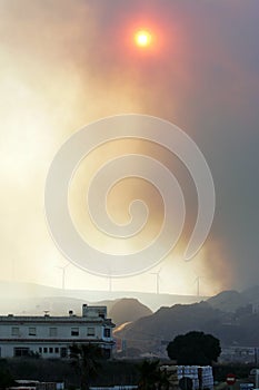 Dull sun shining through smoke from forest fire in Spain photo