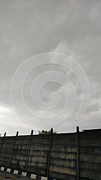 A dull wall with a view of a cloudy sky