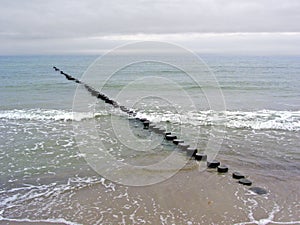 Dull weather and breakwater on the sandy beach